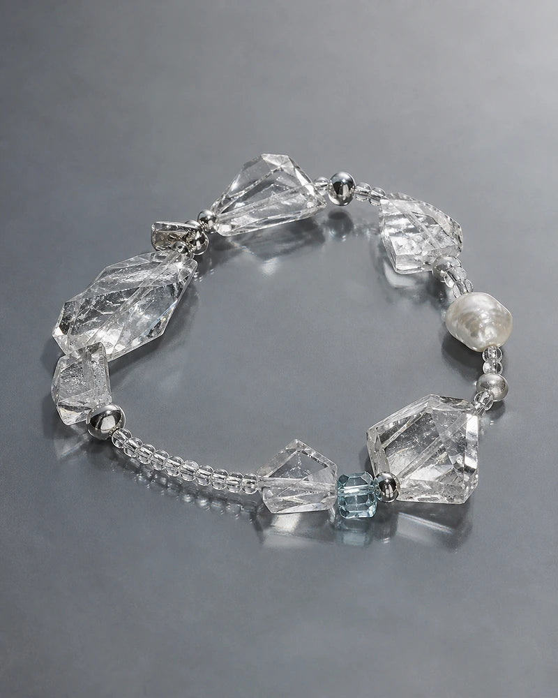 Large faceted clear crystals arranged with a pearl and pale blue bead