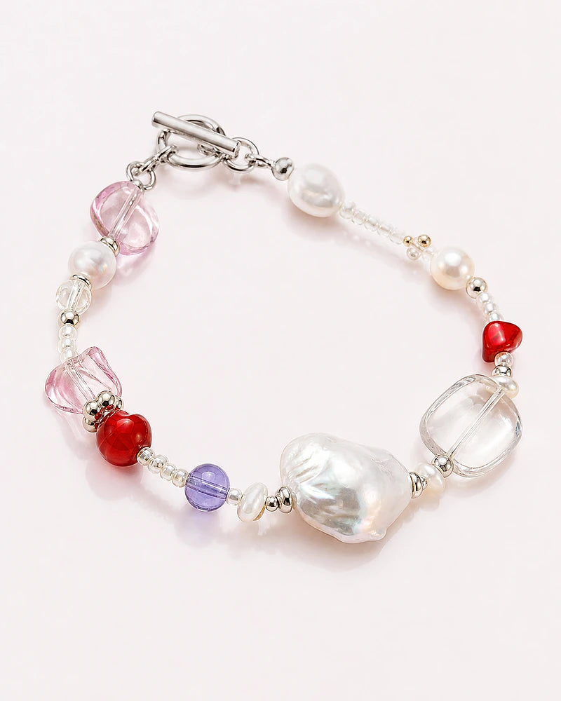 A mixed bracelet with white pearls, pink glass and red accents